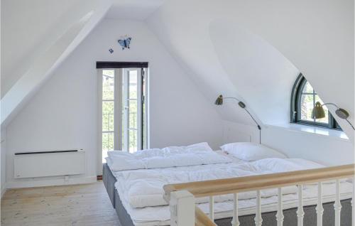 ein weißes Schlafzimmer mit einem großen Bett und einem Fenster in der Unterkunft Amazing Home In Vejby With House Sea View in Vejby