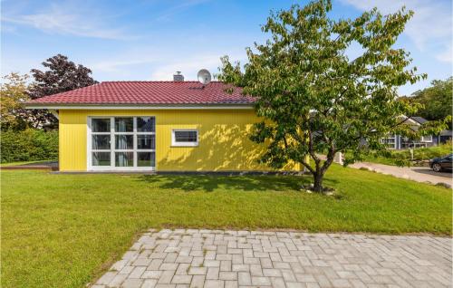 a yellow house with a tree in front of it at Lovely Home In Krems Iiwarderbrück in Göls