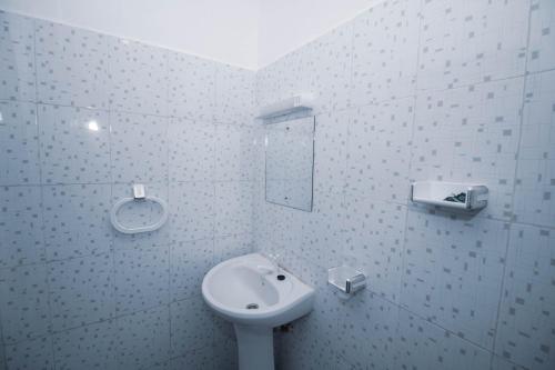 uma casa de banho branca com um lavatório e um espelho em Haven Hearts Apartments em Malindi