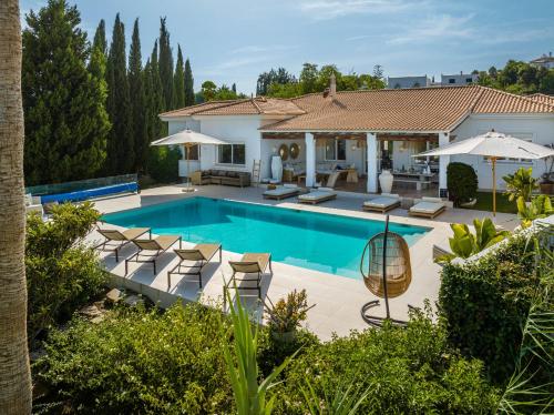 a swimming pool with chairs and a house at VACATION MARBELLA I Villa Ballesteros, Near Golf Courses, Private Pool and Gigantic Garden in Estepona