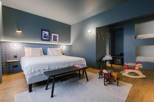 1 dormitorio con 1 cama grande y pared azul en Maison Arya, en Bruselas