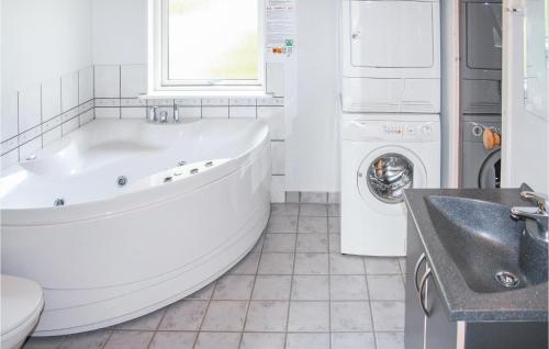 a white bathroom with a tub and a washing machine at Stunning Home In Vestervig With 3 Bedrooms, Sauna And Wifi in Vestervig
