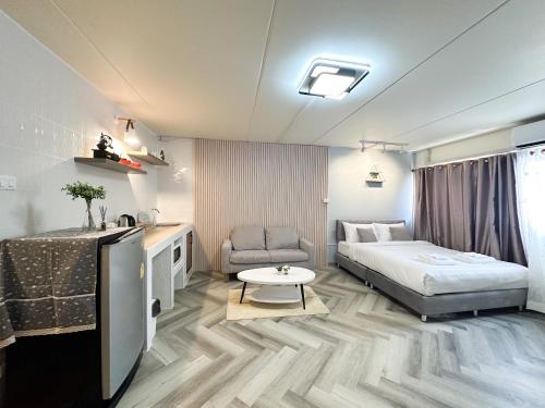 a bedroom with a bed and a couch and a table at NK hostel 31 in Ban Bang Phang