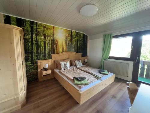 1 dormitorio con 1 cama con una pintura en la pared en Hotel Forsthaus, en Volkesfeld