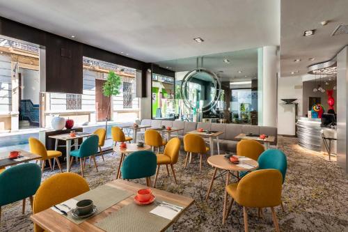 un restaurante con mesas y sillas y un bar en Mariposa Hotel Malaga, en Málaga