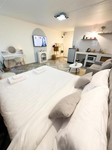 a large white bed in a living room with a couch at NK hostel 31 in Ban Bang Phang