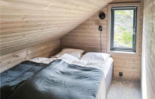 Bett in einem Zimmer mit einer Holzwand in der Unterkunft Nice Home In Edland With Wifi in Botn