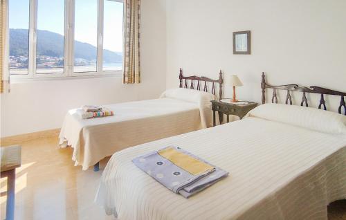 Zimmer mit 3 Betten und einem Fenster in der Unterkunft 4 Bedroom Amazing Apartment In Muros in Muros