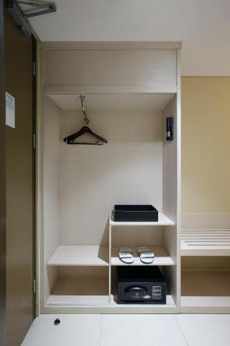 a closet with white shelves and a microwave at Aston Banyuwangi Hotel and Conference Center in Banyuwangi