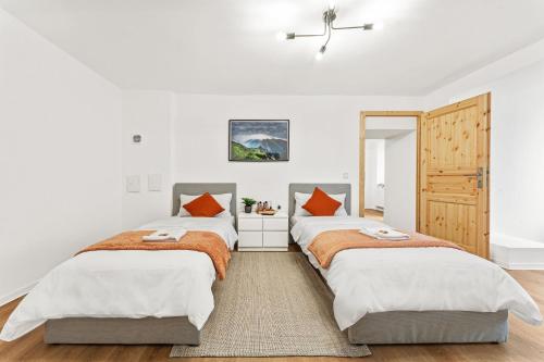 two beds in a bedroom with white walls and wood floors at 2 Zimmer, 4 Betten, vollmöbliert,zentrale Lage am S-Bahnhof in Berlin