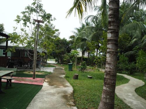a park with a palm tree and a sidewalk at BB Durio Chalet in Kampong Banggol Binjai