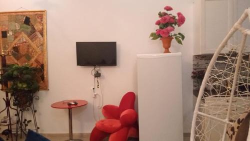 Studio في دهب: غرفة معيشة فيها تلفزيون وكرسي احمر