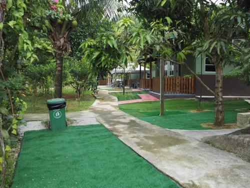 a green lawn with a trash can on it at BB Durio Chalet in Kampong Banggol Binjai