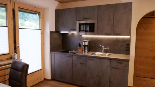 a kitchen with a sink and a counter top at Bucherwirt Appartements in Buch bei Jenbach