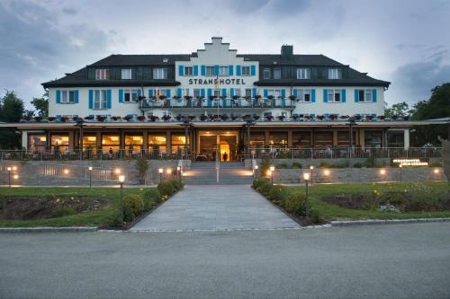 a large blue building with lights in front of it at Strandhotel Löchnerhaus in Reichenau