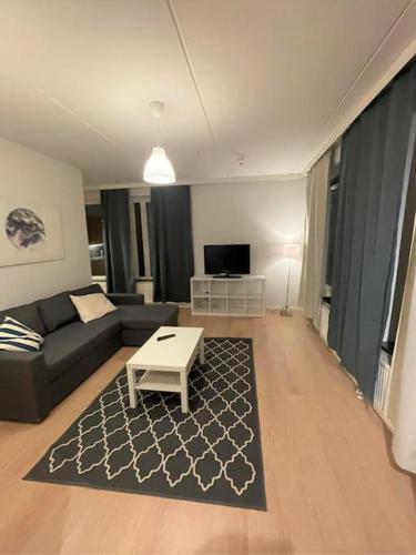 ein Wohnzimmer mit einem Sofa und einem Couchtisch in der Unterkunft Kotimaailma - Saunallinen kolmio Herttoniemessä in Helsinki