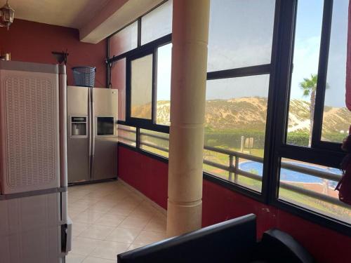 Una cocina con un gran ventanal con vistas a la montaña. en Appartement au bord de l'eau, en Mohammedia