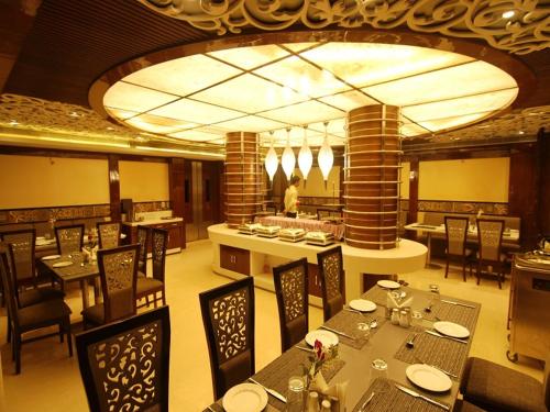 uma sala de jantar com mesas e cadeiras e um restaurante em Hotel Costa River em Varanasi