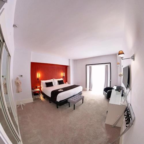 a hotel room with a bed and a large window at Mariposa Hotel Malaga in Málaga