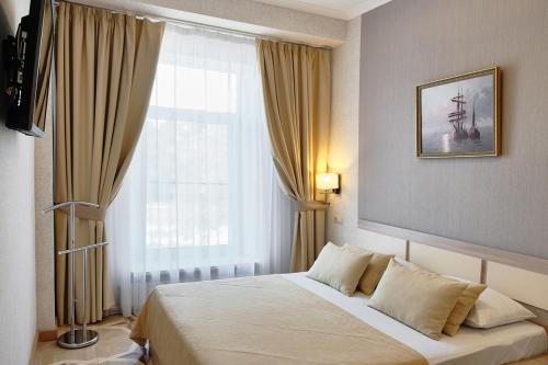 a bedroom with a bed and a large window at Intourist Hotel in Velikiy Novgorod