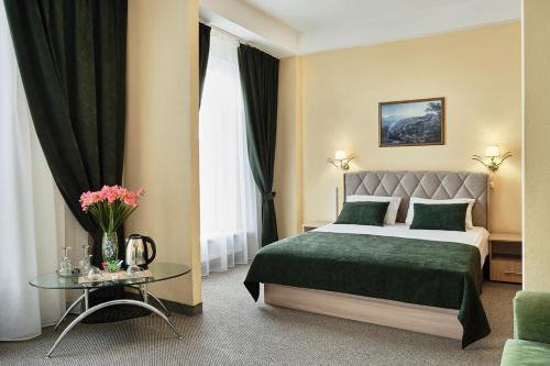 une chambre d'hôtel avec un lit et une table dans l'établissement Intourist Hotel, à Novgorod