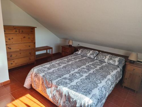 una camera con letto e cassettiera di La Triqueta a Zarzuela del Monte