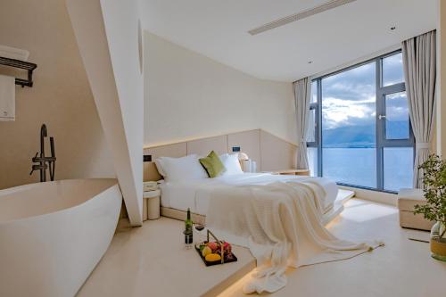 a bedroom with a large bed and a large window at Dali Oriental Seaview Hotel -Dali Erhai in Dali