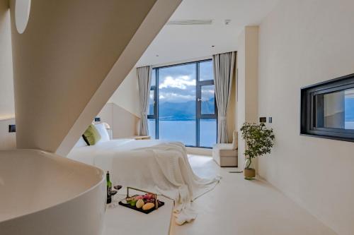 a bedroom with a bed with a view of the ocean at Dali Oriental Seaview Hotel -Dali Erhai in Dali
