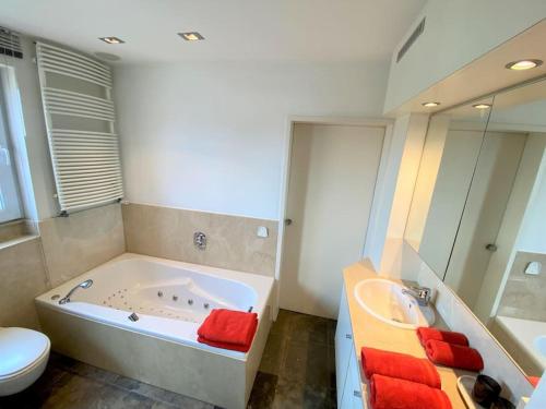 y baño con bañera, aseo y lavamanos. en Vakantieappartement 'Golf Azur', en Middelkerke