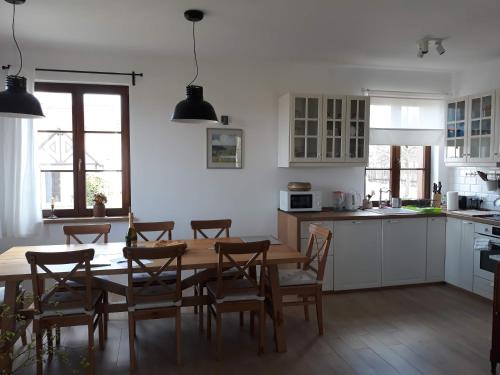 uma cozinha com uma mesa de madeira e cadeiras numa cozinha em Wyskok 1 - dom z widokiem em Srokowo