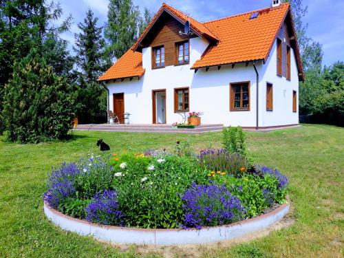 una casa con techo naranja y jardín de flores en Wyskok 1 - dom z widokiem, en Srokowo