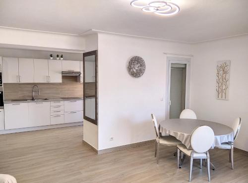 une cuisine et une salle à manger avec une table et des chaises dans l'établissement Residence les Etoiles, à Juan-les-Pins