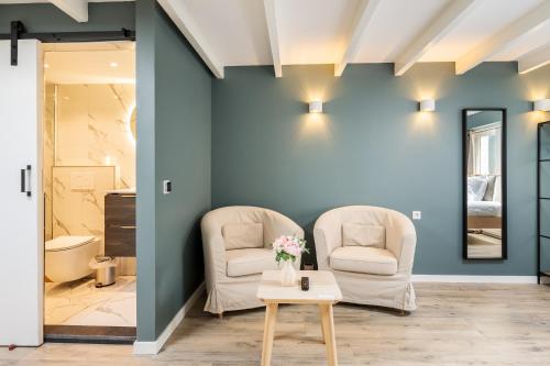 een woonkamer met 2 stoelen en een tafel bij Studio Luxe 31 Zandvoort met gratis parkeerplaats in Zandvoort