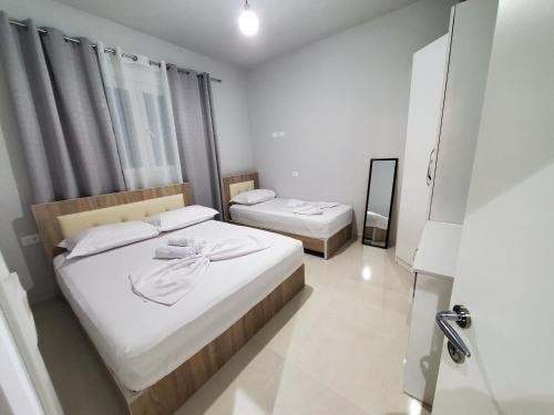 - une petite chambre avec 2 lits et un miroir dans l'établissement Twins Apartment, à Përmet