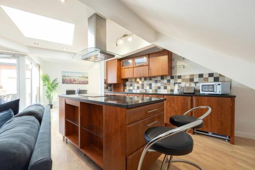 a kitchen with a couch and a kitchen island in a room at Withington Apartments in Manchester