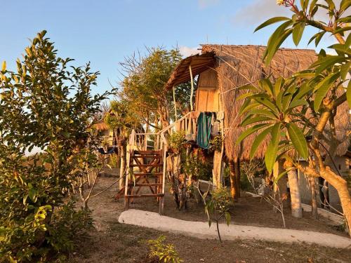 uma pequena casa com uma escada em frente em Eco Tourist Dream Stay Tree House em Nusa Penida