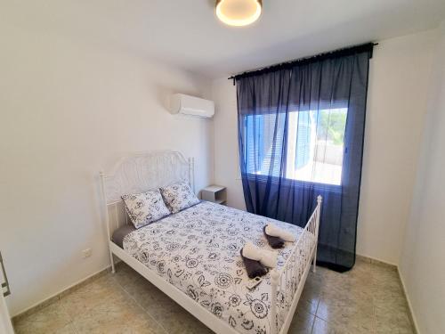 1 dormitorio con cama blanca y ventana en Beach Vibes Apartment, en Pyla