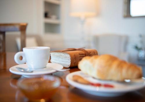 a table with a cup of coffee and a loaf of bread at Grand Hotel Palace in Ancona
