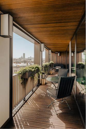 a balcony with chairs and a view of the city at Bvlgari Hotel Paris in Paris