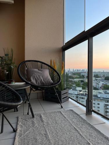 a balcony with a chair and a table with a view at Wiatraczna 136 in Warsaw