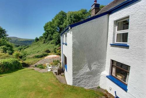 a white house with a window and a yard at 2 bed rural retreat nestled in the heart of Exmoor in Parracombe