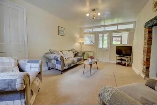 a living room with two couches and a tv at 2 bed rural retreat nestled in the heart of Exmoor in Parracombe
