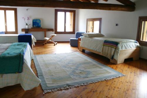 um quarto com 2 camas e um tapete em B&B Allo Spizzo em Valstagna
