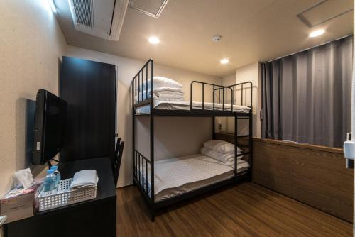 a room with two bunk beds and a desk at Soosong Guesthouse in Seoul
