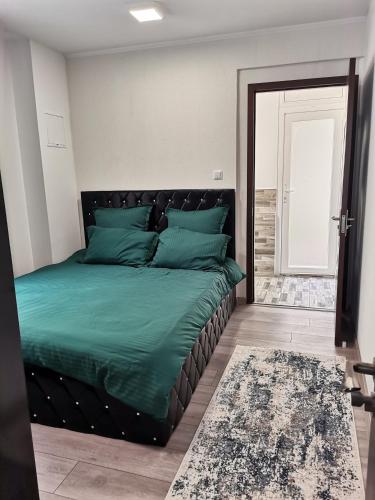 um quarto com uma cama com um edredão verde em Apartament Sonya em Bucareste