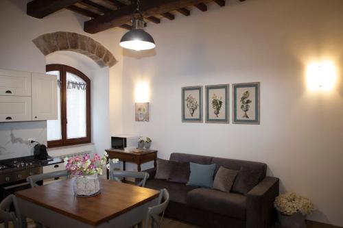 salon z kanapą i stołem w obiekcie Residenza Porta Perlici Assisi Apartment w Asyżu
