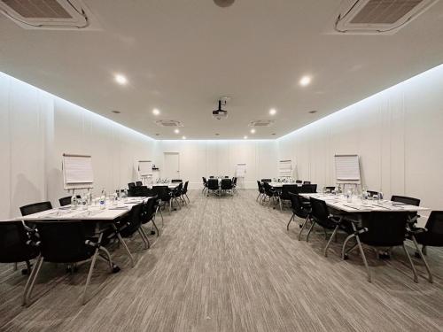 uma grande sala com mesas e cadeiras em Wellness Stay & Hotel Sukhumvit 107 em Bang Na