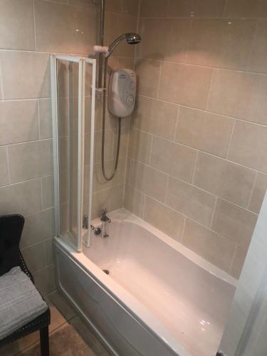 a bathroom with a bath tub with a shower at Little Retreat in Woodhouse