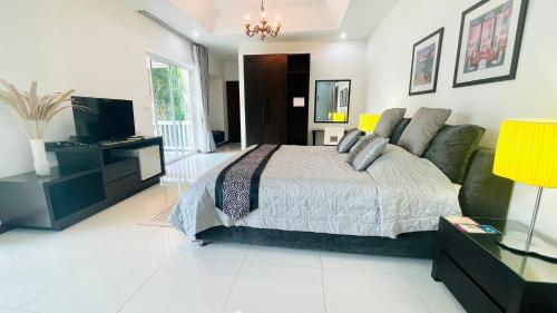 a bedroom with a bed and a couch and a television at Baan Ing Khao in Pak Chong