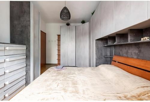 una camera con un grande letto e una parete di cemento di Appartamento Milano a Milano